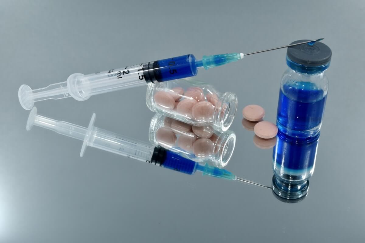 Image of a COVID vaccine with some pills